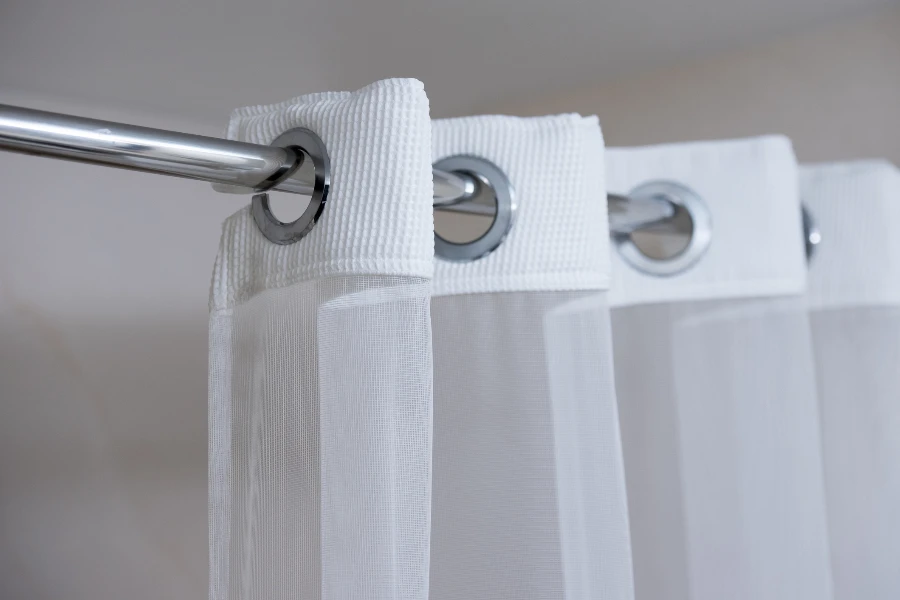white shower curtain with eyelets on curtain rod