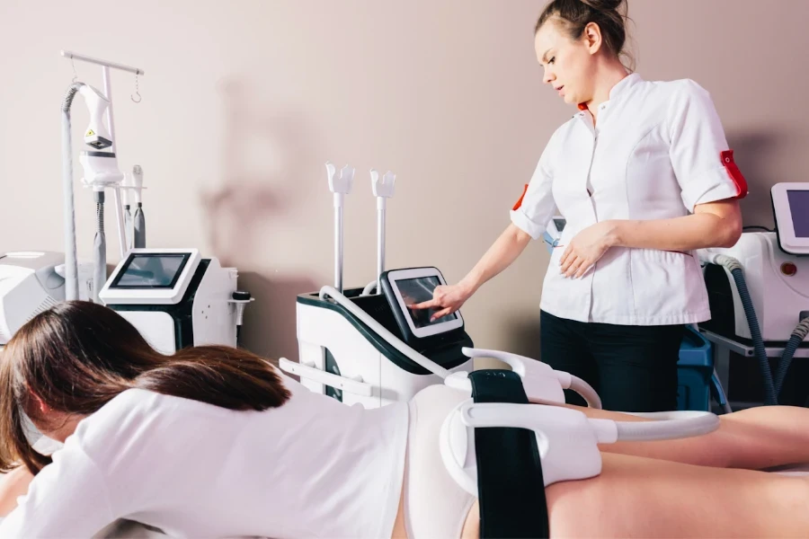 Woman giving her patient EMS sculpting treatment