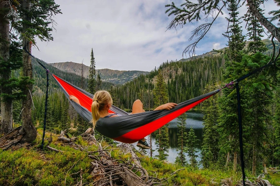 Mujer en una hamaca con vistas a un bosque verde