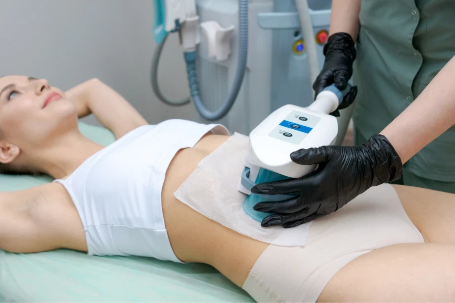 Mujer en camiseta y bragas recibiendo tratamiento de escultura EMS