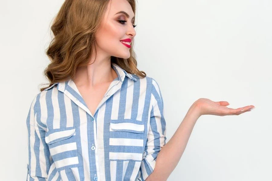 Femme posant dans une chemise à rayures blanches et bleues