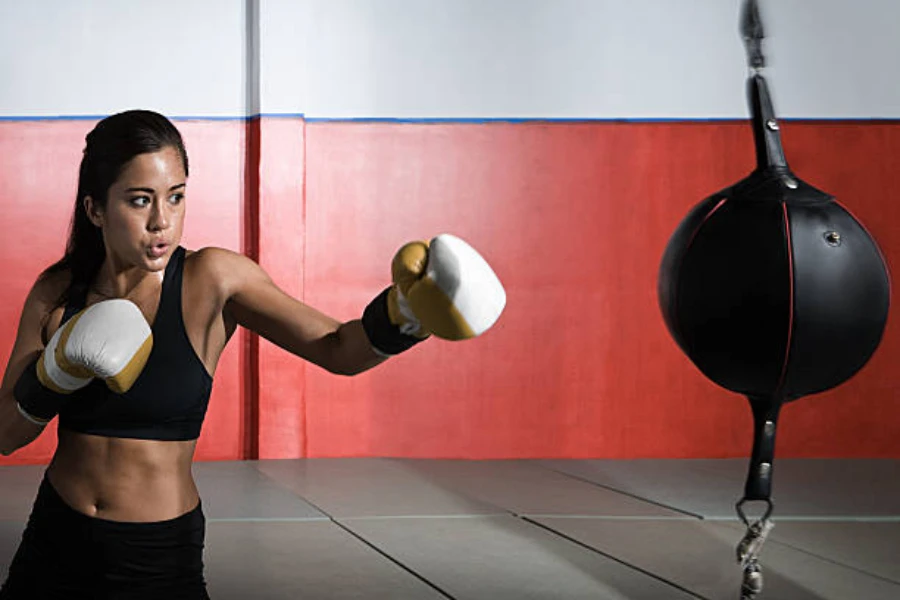 Woman punching black double-end bag in training center