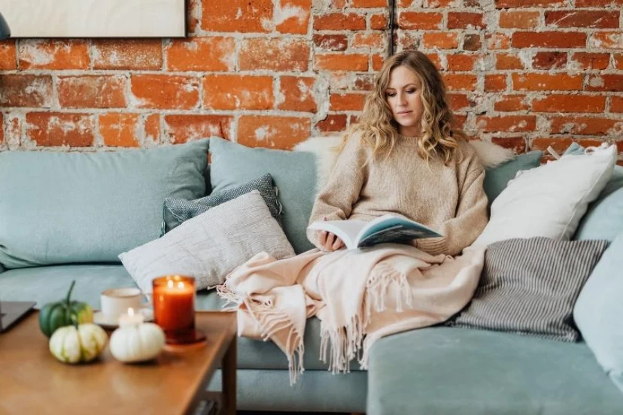 Woman reading under pink cashmere fringe throw blanket