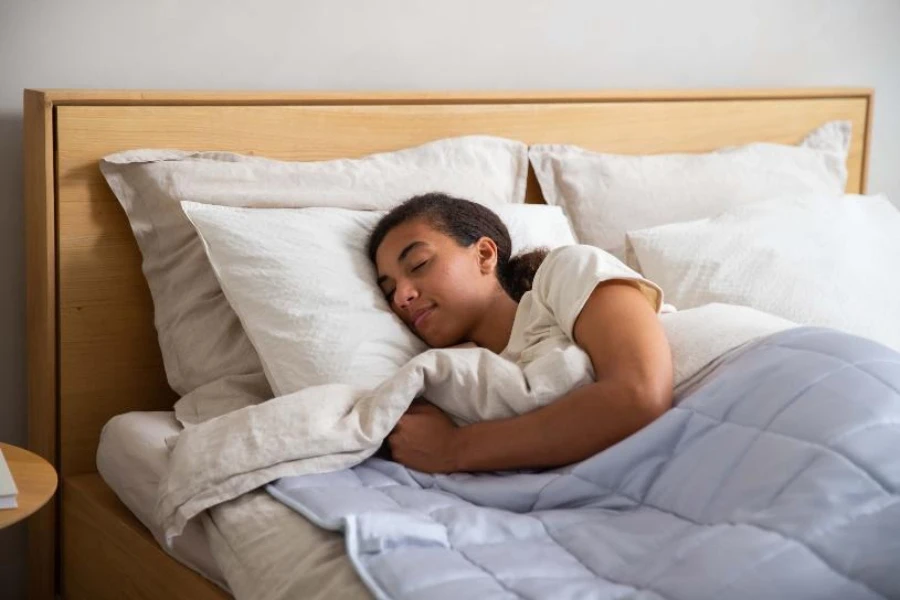 Donna che dorme nel letto con coperta trapuntata