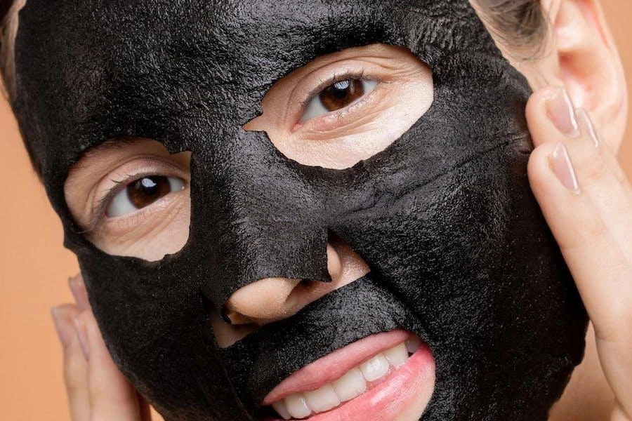 Mulher usando uma máscara facial de carvão