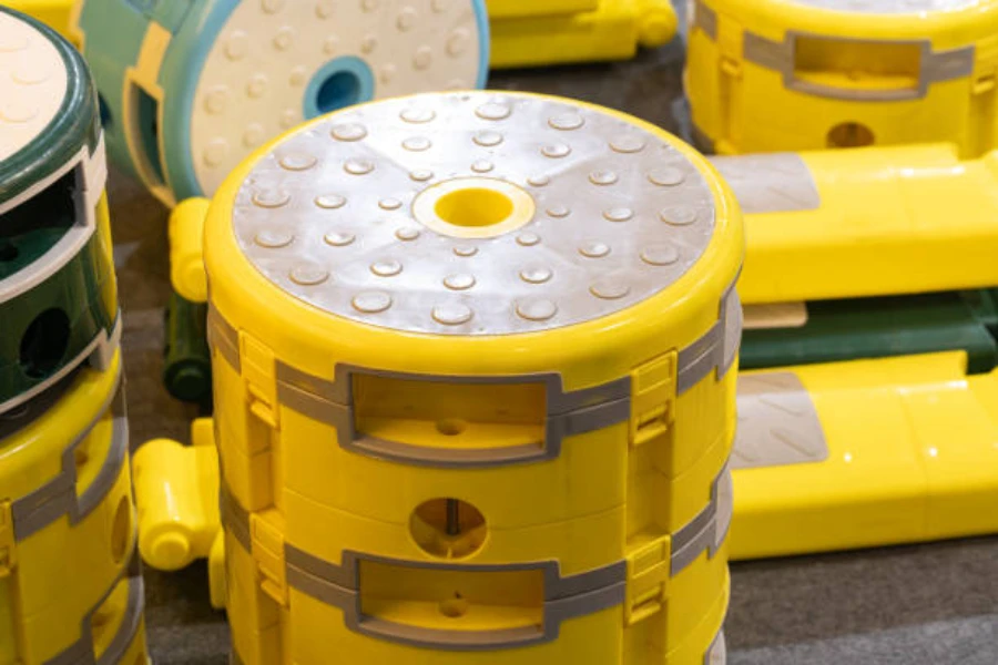 倉庫にバンドルで置かれている黄色の調節可能なキャンプ用スツール
