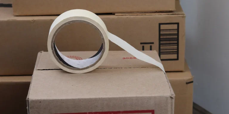 A roll of adhesive tape on a cardboard box