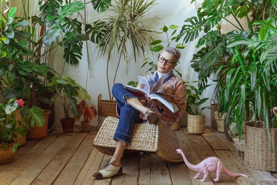 A woman sitting and reading on a rocking chair