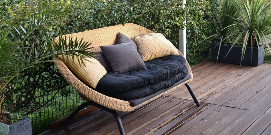 An outdoor sofa with cushions in a tropical garden