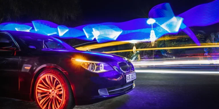 Автомобиль марки BMW в городе в интересном освещении