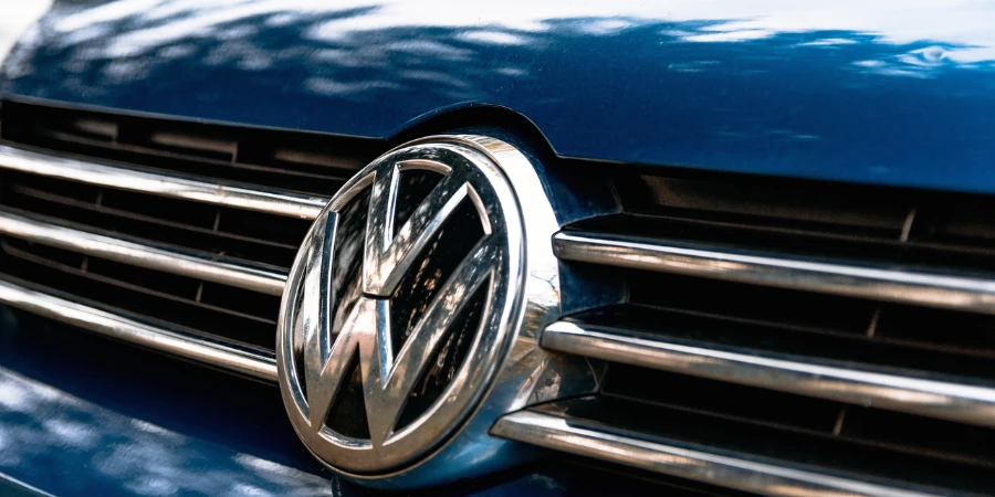 Closeup of a Volkswagen logo on the grille of a blue car
