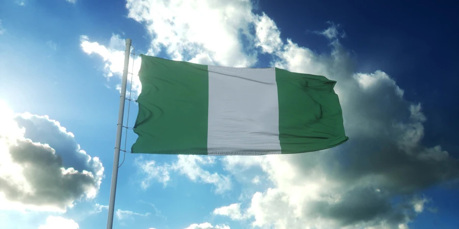 Die Flagge Nigerias weht im Wind vor dem wunderschönen blauen Himmel
