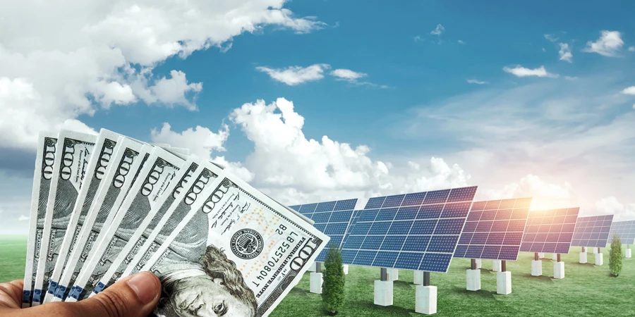 Tangan dengan dolar di latar belakang panel surya