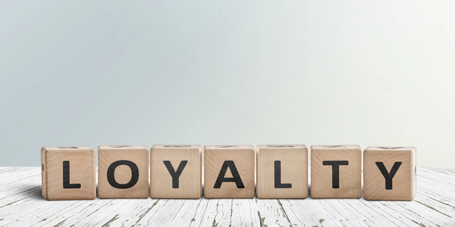 Loyalty sign on a wooden table in bright daylight