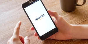 Man hand holding screen shot of Amazon application