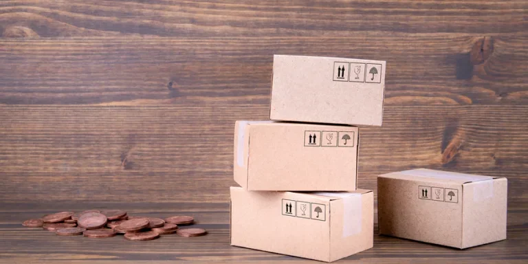 Paper boxes and cash coins on wooden background