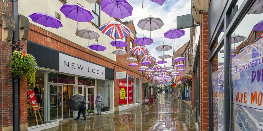 Purple umbrellas hang above the rainy wet