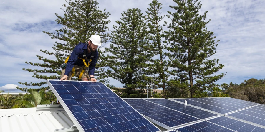 Technicien en panneaux solaires installant des panneaux solaires sur le toit