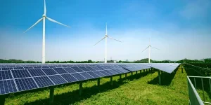 Solar panels and wind generators under blue sky on sunset