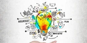 Tangan wanita dan bola lampu berwarna-warni, beton