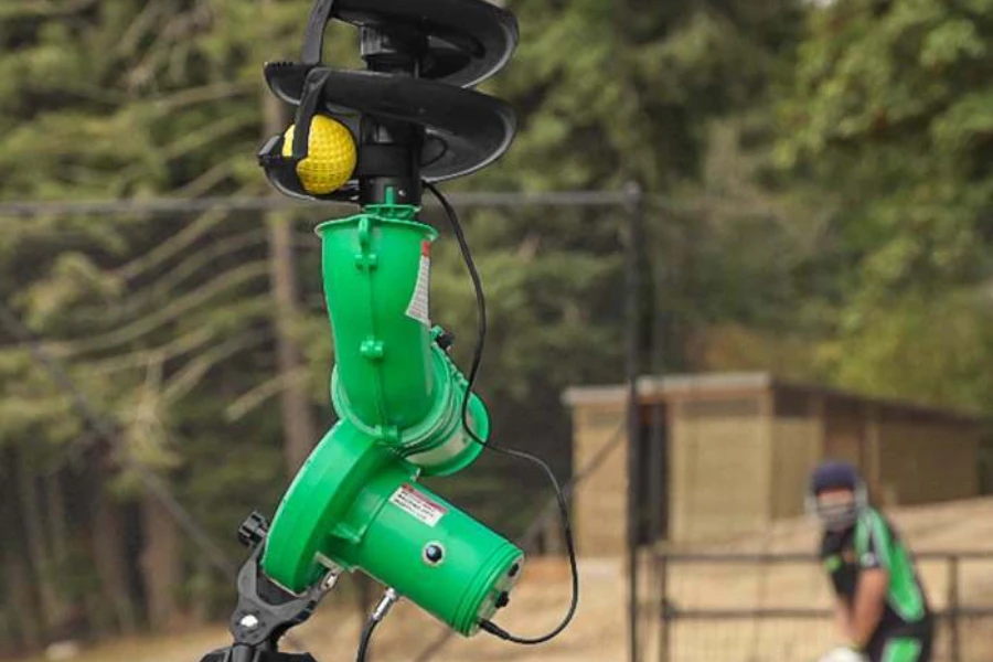A green and black bowling machine with a ball