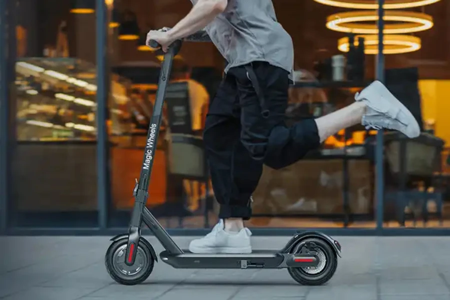 Un hombre montando un scooter eléctrico.