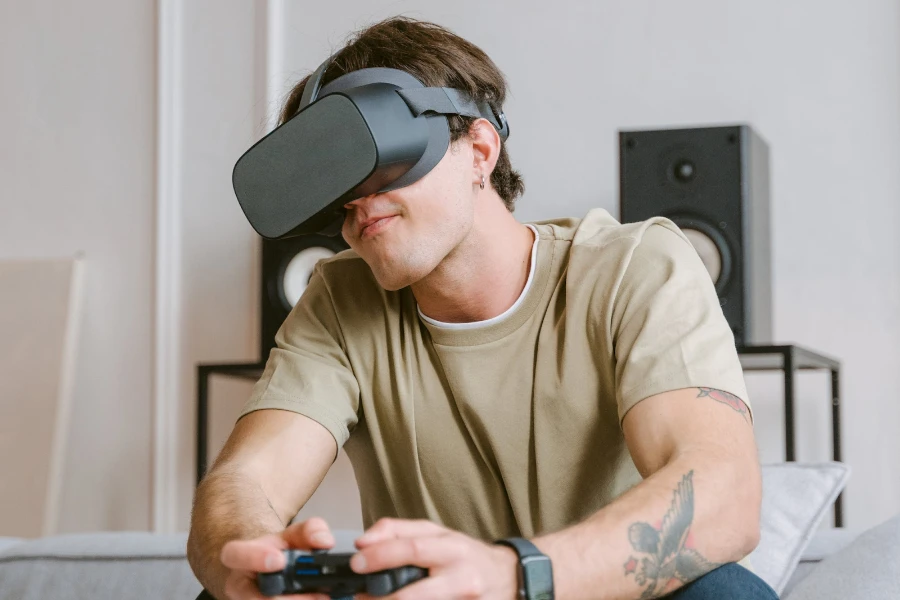 Seorang pria menggunakan konsol game genggam dan headset VR