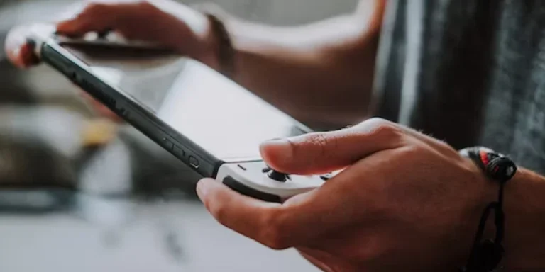 A person holding a handheld gaming console