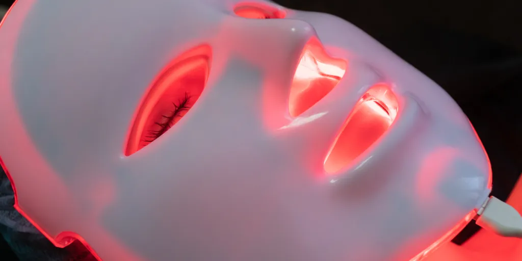 A person wearing a red light therapy mask