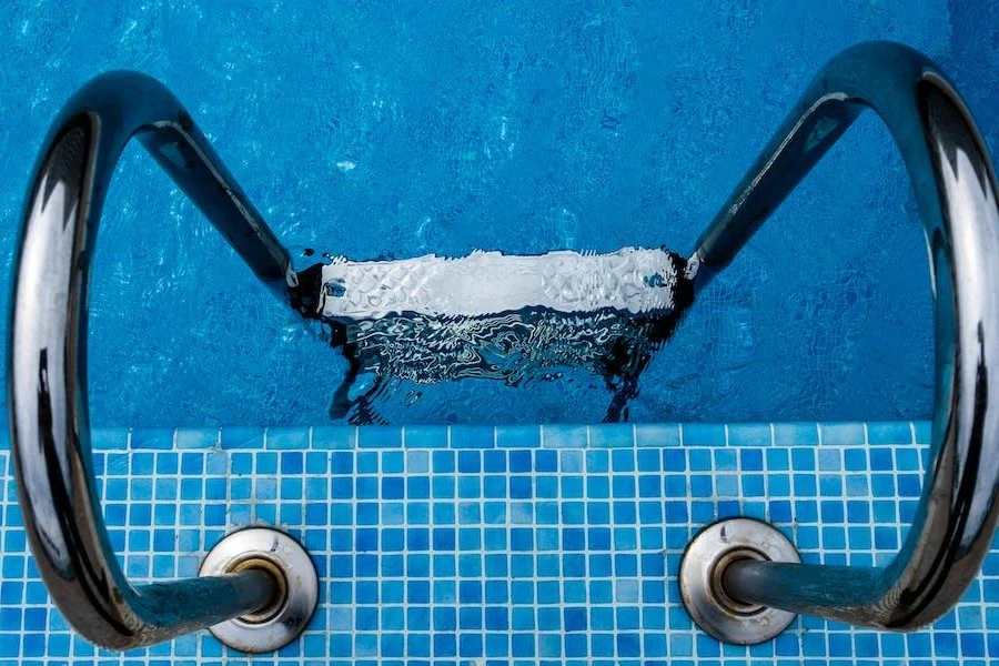 Una scaletta per piscina con gradini bianchi antiscivolo