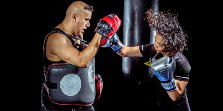 A woman punching a man’s gloved hand