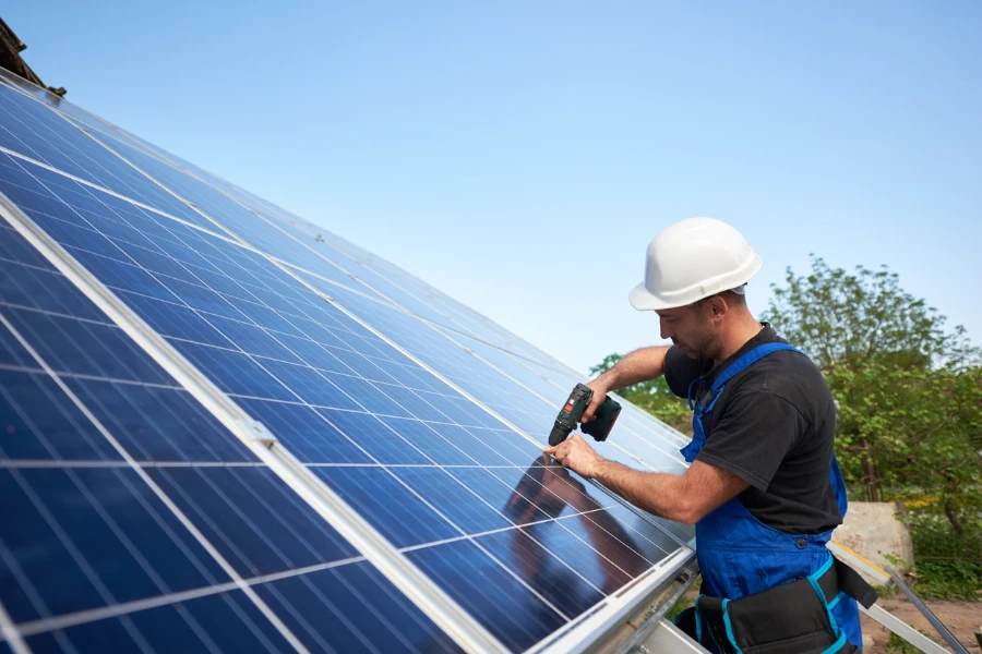 Um trabalhador instalando painéis solares