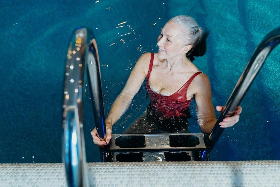 Eine ältere Frau klettert aus einem Pool
