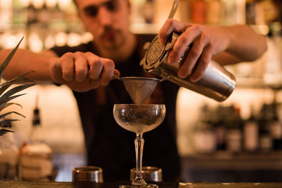 Barman versant un verre dans un verre