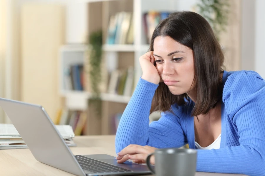 Bored woman checking her laptop