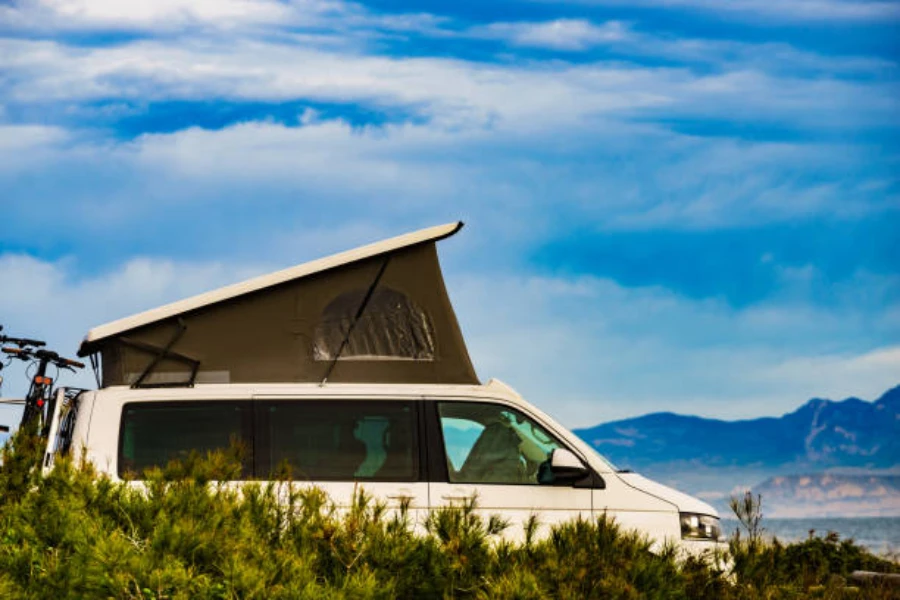 Camper van with an expanded pop-up rooftop tent