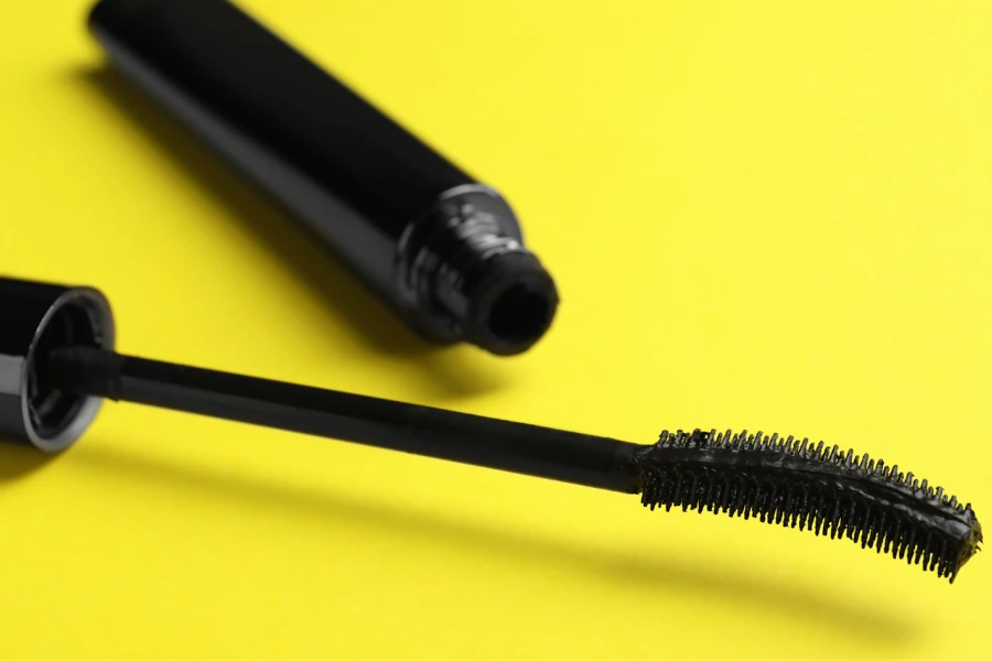Curved mascara wand on yellow background