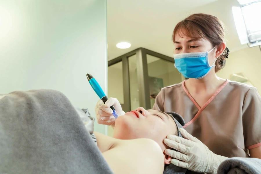 Bir hastayı IPL güzellik cihazıyla tedavi eden dermatolog