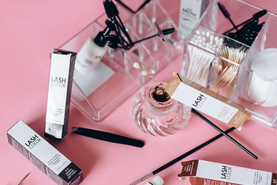 Different eyebrow extension tools on a pink table