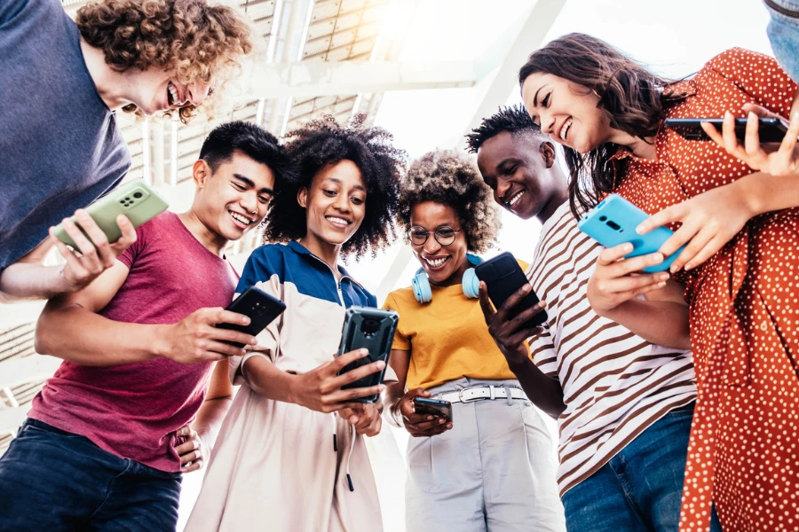 Diversi adolescenti che utilizzano smartphone digitali