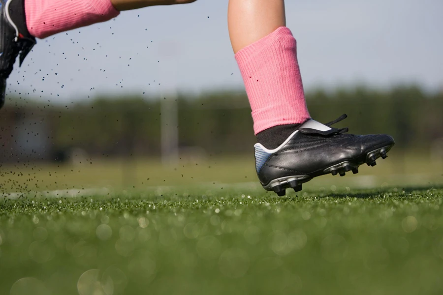 Девушка-футболистка бежит