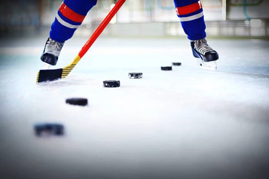 Giocatore di hockey su ghiaccio in fila per colpire i dischi nella rete