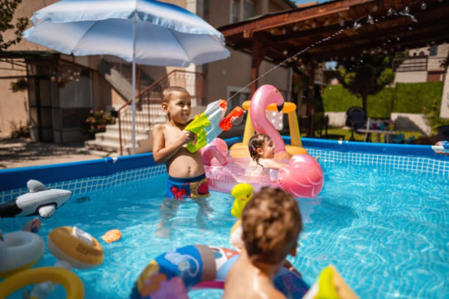Niños jugando con una selección de juguetes para la piscina en verano.