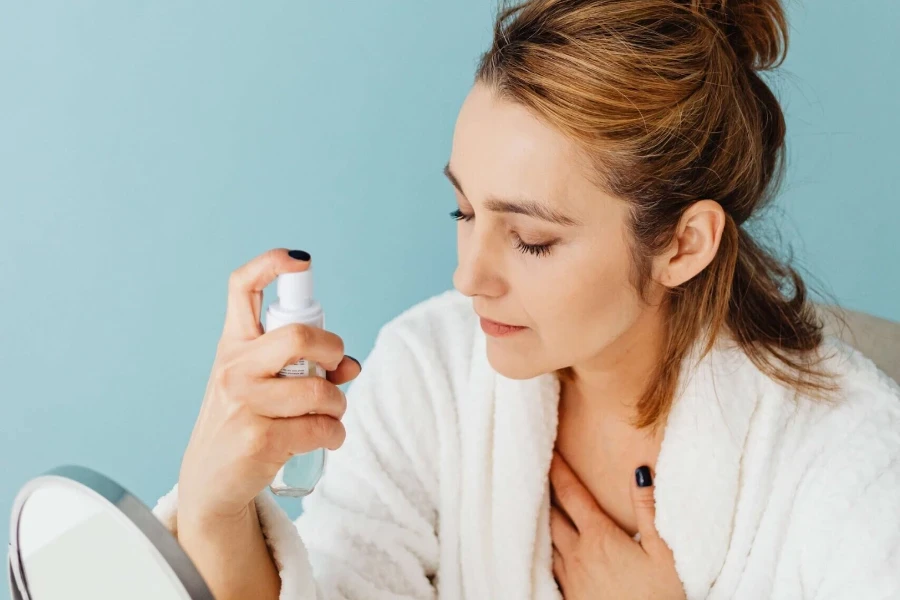 Senhora fechando os olhos enquanto aplica spray de fixação