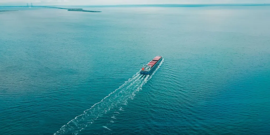 ターコイズブルーの海を航行する大型輸送貨物船