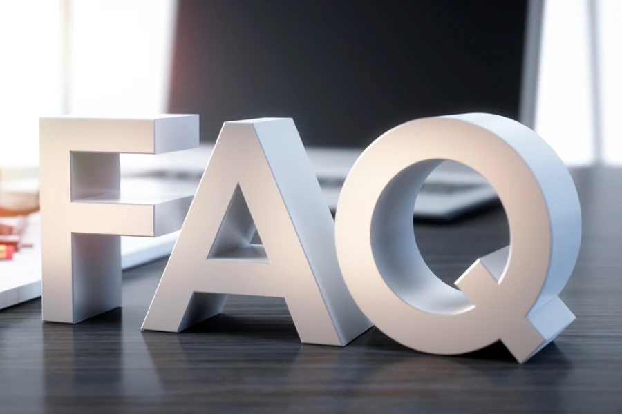 Buchstaben „FAQ“ auf einem Schreibtisch