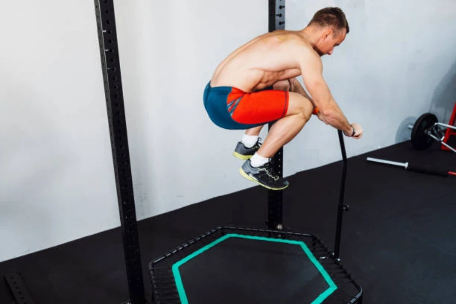 L'uomo salta sul trampolino pieghevole all'interno di una palestra