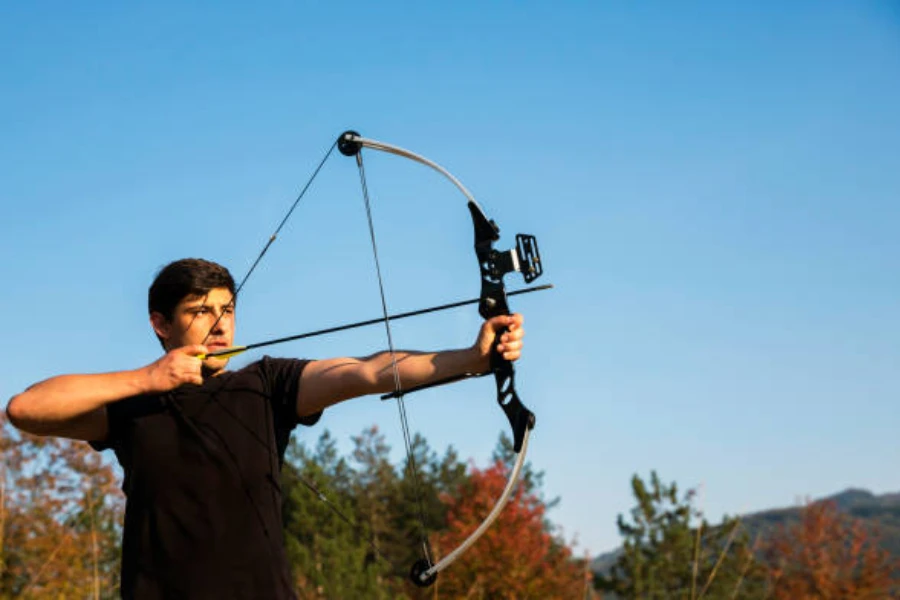 Man pulling back arrow on recurve bow to shoot it