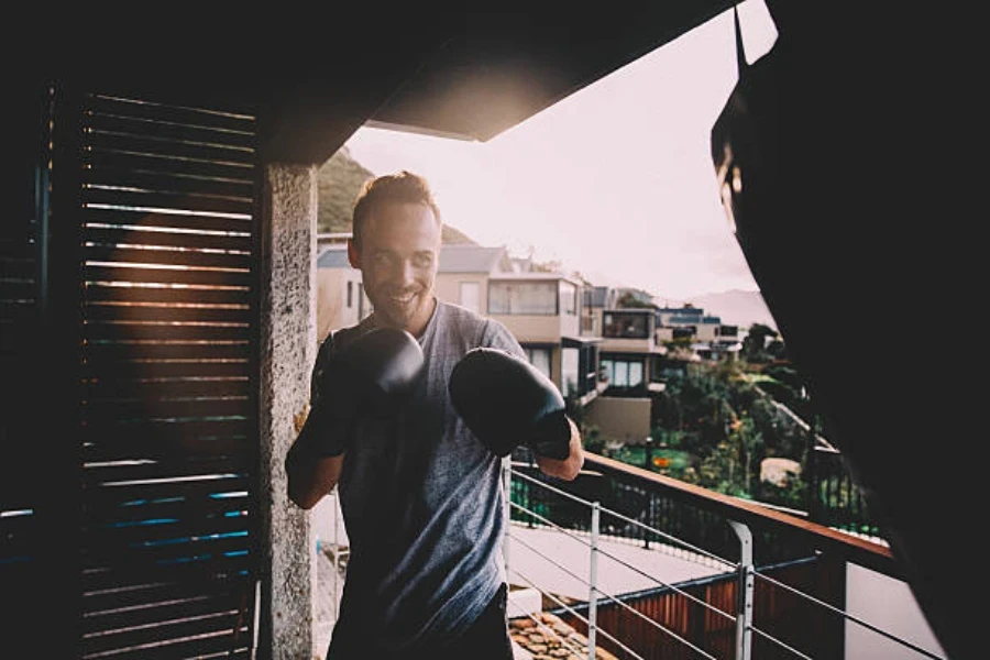 Man using a punching bag standing on his balcony