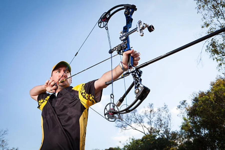 Man using an advanced compound bow to shoot arrow outside